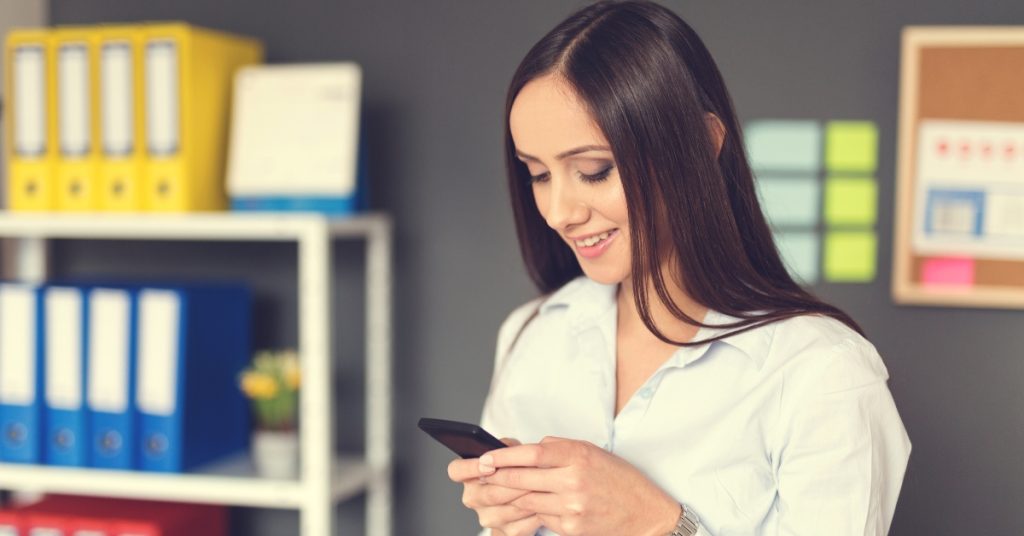Woman writing a message on a smartphone