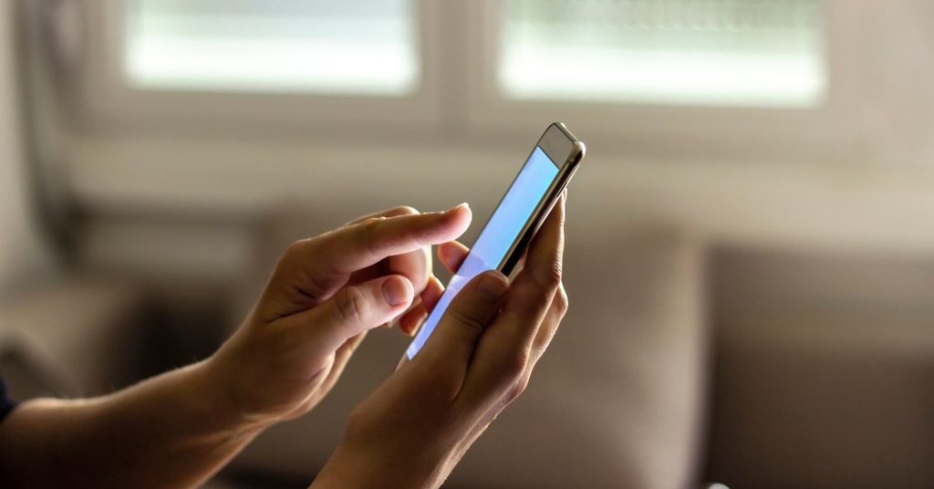 Main qui utilise un chatbot sur un smartphone